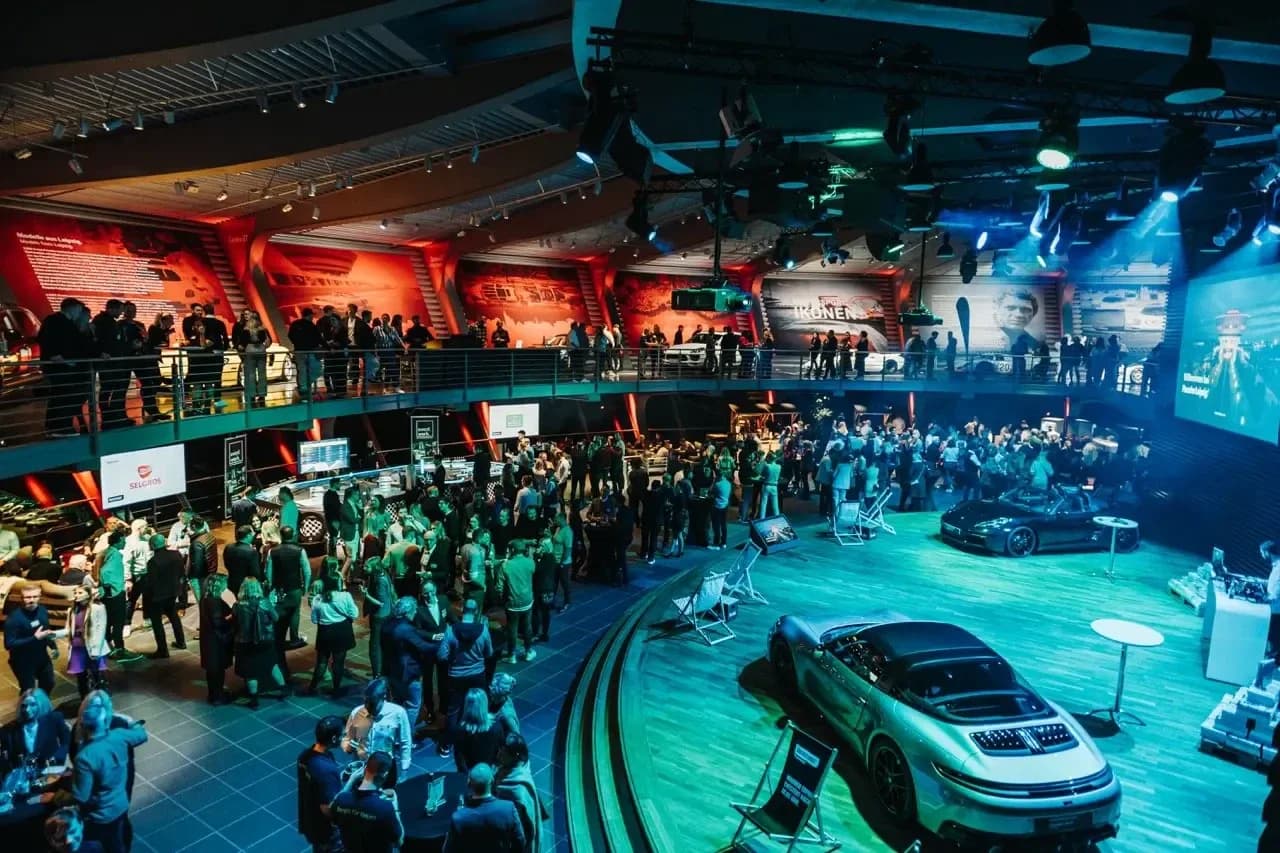 ÜBERSTUNDE Leipzig × SELGROS: die volle Eventhalle mit Gästen und ausgestellten Sportwagen